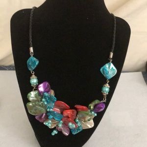 Lovely shell necklace on a braided leather band. It measures 22 inches long